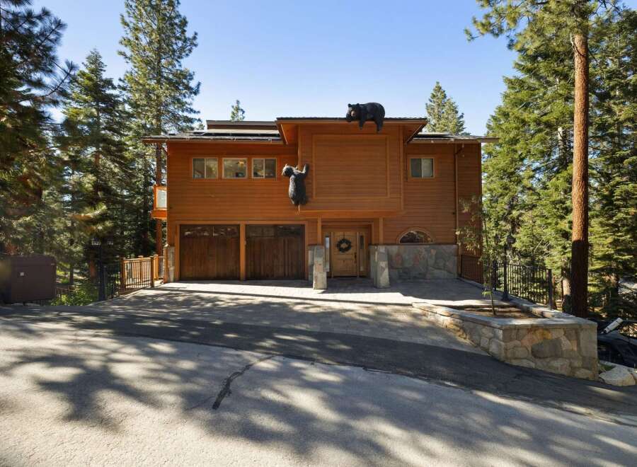 Discover this charming mountain home featuring a rustic wood exterior and a unique bear-themed facade, perfect for a nature lover's retreat.