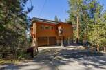 Nestled amongst towering pine trees, this charming wooden home offers a unique mountain retreat.
