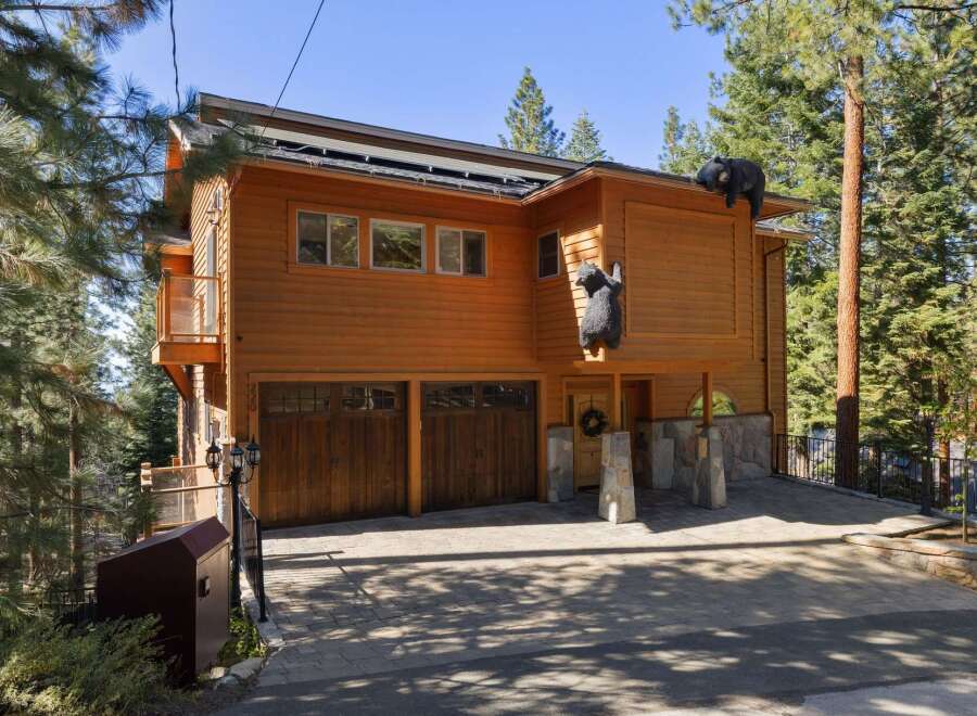 Experience the unique charm of this mountain retreat, featuring a striking wooden exterior adorned with playful bear sculptures.