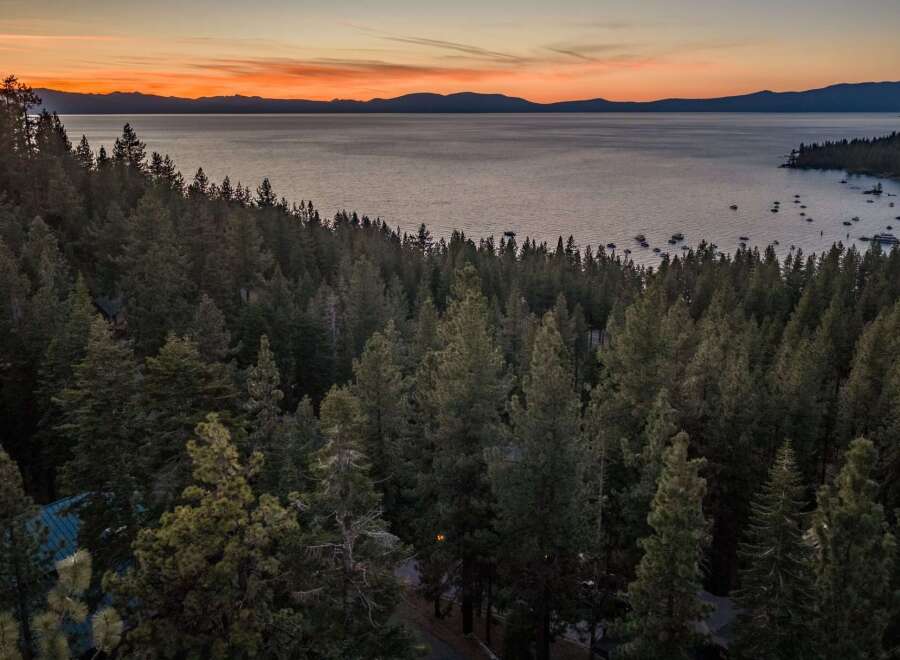Experience breathtaking sunset views over Lake Tahoe from this stunning property nestled amongst towering pine trees.