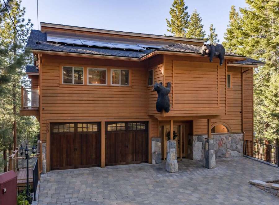 Experience mountain living in this stunning wooden home featuring a unique bear-themed exterior decoration.