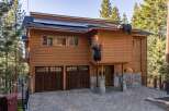 Experience mountain living in this stunning wooden home featuring a unique bear-themed exterior decoration.