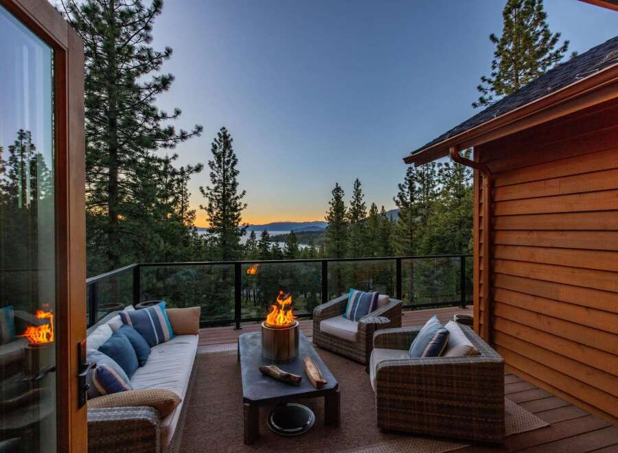 Experience breathtaking sunset views from this stunning mountain retreat's expansive deck, complete with a cozy fire pit and comfortable seating.