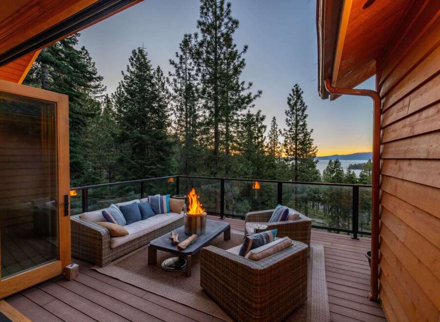 Experience breathtaking sunset views from this stunning deck, complete with a cozy fire pit and comfortable outdoor seating.