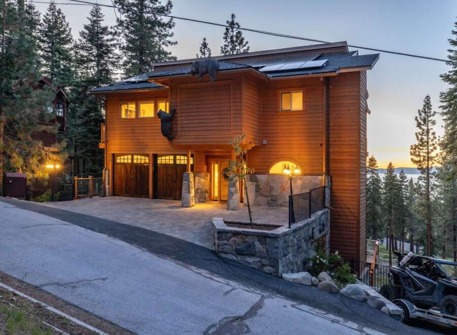 Experience luxury mountain living in this stunning wood-sided home, featuring a unique bear-themed exterior and a spacious multi-car garage.