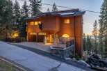 Experience luxury mountain living in this stunning wood-sided home, featuring a unique bear-themed exterior and a spacious multi-car garage.