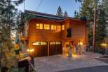 Experience luxury mountain living in this stunning wooden home, featuring a unique bear-themed exterior and a spacious paver driveway leading to a double garage.