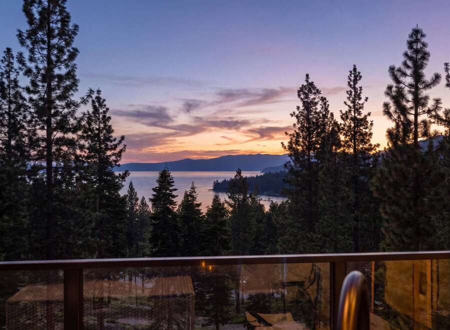 Experience breathtaking sunset views over the lake from this stunning property, framed by majestic pine trees.