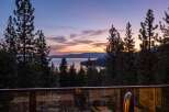 Experience breathtaking sunset views over the lake from this stunning property, framed by majestic pine trees.
