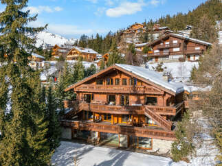 Experience luxury mountain living in this stunning wooden chalet, nestled amidst snow-covered peaks and evergreen forests.