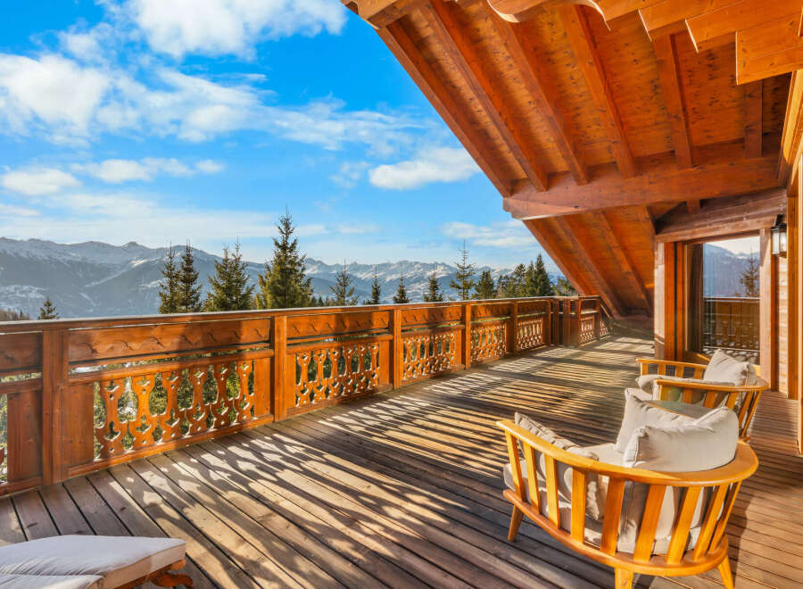 Experience breathtaking mountain vistas from this stunning wooden balcony, perfect for enjoying your morning coffee or evening relaxation.