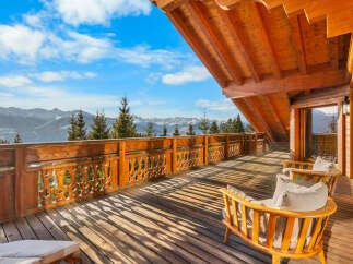 Experience breathtaking mountain vistas from this stunning wooden balcony, perfect for enjoying your morning coffee or evening relaxation.