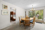 This dining area features a large wooden table with six chairs, perfect for family meals.