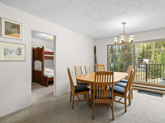 This dining area features a large wooden table with six chairs, perfect for family meals.