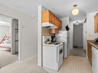 Discover this charming kitchen featuring warm wooden cabinetry and a functional white stove.