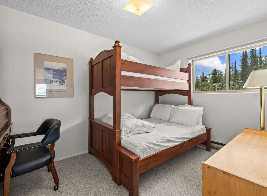 This charming bedroom features a sturdy wooden bunk bed, perfect for accommodating guests or family.