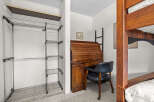 This bedroom offers a space-saving solution with a built-in closet system and a compact desk area, perfect for students or small living spaces.