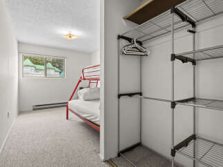 This charming bedroom features a space-saving red bunk bed, perfect for families or guests.