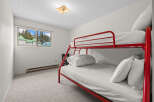 This charming bedroom features a vibrant red bunk bed, perfect for families or guests.