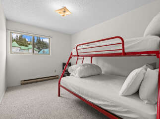 This charming bedroom features a vibrant red bunk bed, perfect for families or guests.