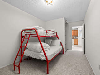 This charming bedroom features a vibrant red bunk bed, perfect for accommodating guests or children.