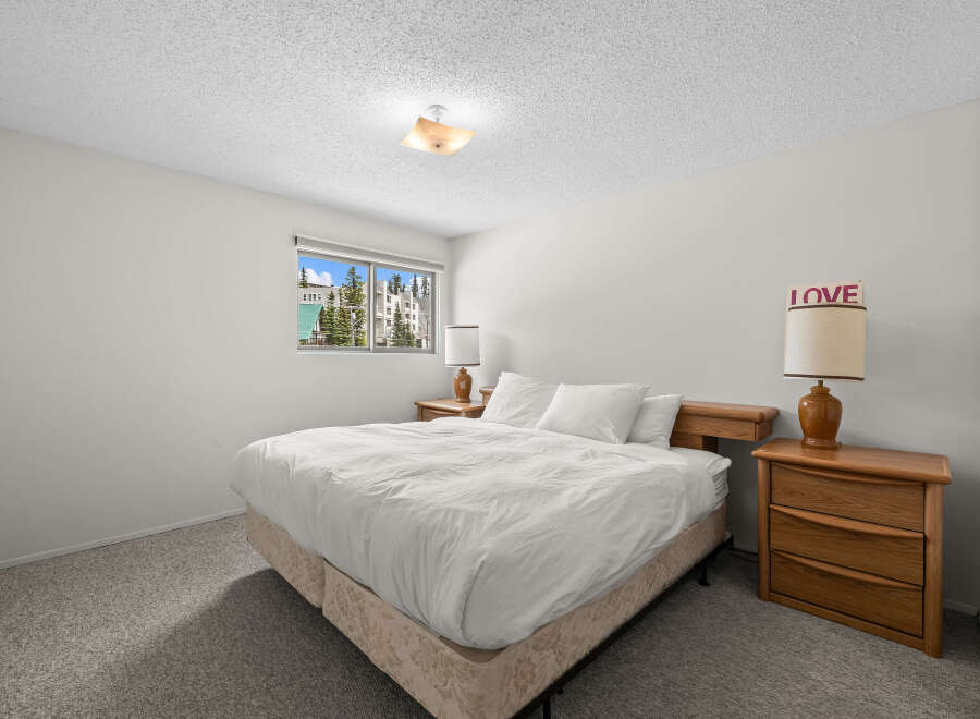 Experience comfort and style in this inviting bedroom, featuring a plush queen-size bed dressed in crisp white linens.