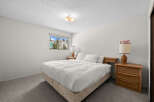 Experience comfort and style in this inviting bedroom, featuring a plush queen-size bed dressed in crisp white linens.