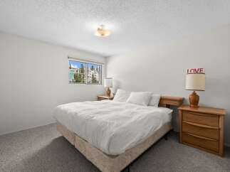 Experience comfort and style in this inviting bedroom, featuring a plush queen-size bed dressed in crisp white linens.
