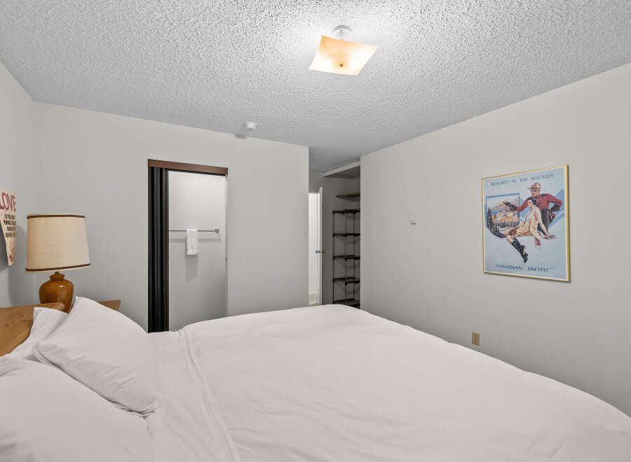 Step into this inviting bedroom featuring a comfortable bed dressed in crisp white linens, perfect for a restful night's sleep.