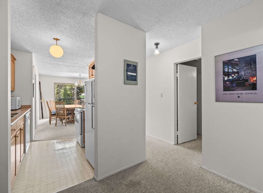 Discover a charming interior featuring a well-equipped kitchen with ample cabinet space and a dining area perfect for family meals.
