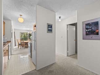 Discover a charming interior featuring a well-equipped kitchen with ample cabinet space and a dining area perfect for family meals.