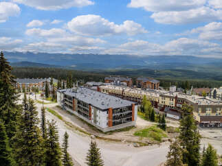 Discover this stunning mountain resort property offering modern condominium living with breathtaking panoramic views of snow-capped peaks and lush evergreen forests.