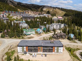 Discover modern mountain living in this multi-unit complex, featuring a contemporary facade with vibrant orange and green accents.