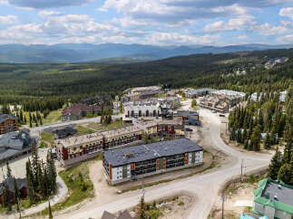 Discover this stunning mountain resort village, offering a collection of modern condominiums nestled amidst a dense evergreen forest.
