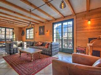 Experience rustic charm in this inviting living room, featuring exposed wooden beams and warm wood paneling.