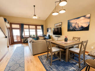 Experience comfortable living in this inviting open-concept space, featuring a spacious living area with a cozy sofa and a dining area perfect for gatherings.