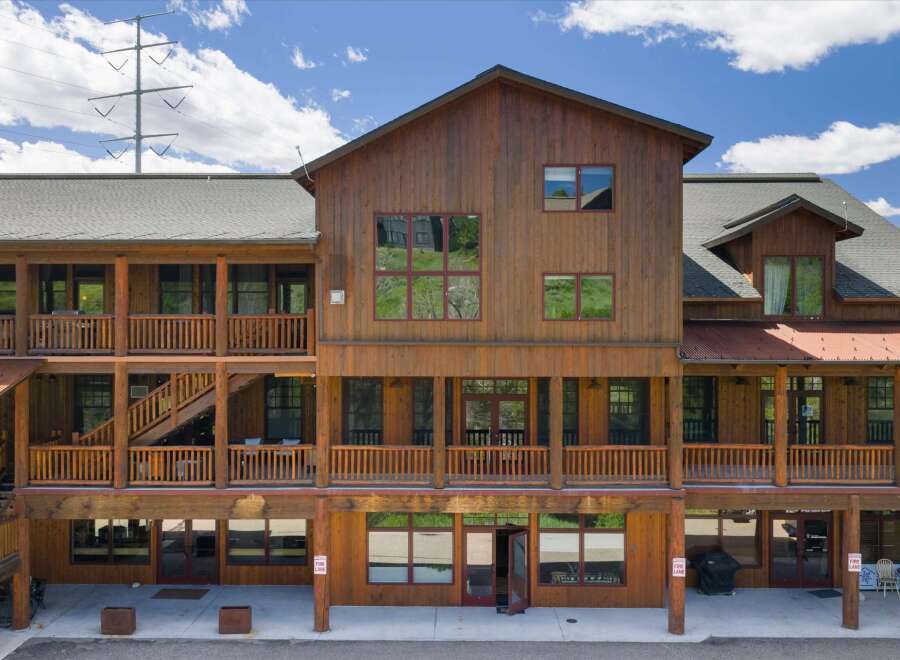 Discover this charming multi-story wooden building, featuring multiple balconies and covered walkways perfect for enjoying the outdoors.