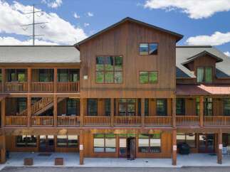 Discover this charming multi-story wooden building, featuring multiple balconies and covered walkways perfect for enjoying the outdoors.
