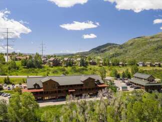 Discover this expansive property featuring a large, multi-story building with ample parking and scenic mountain views.