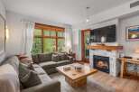 Cozy up by the fireplace in this inviting living room, featuring a plush sectional sofa perfect for relaxing.