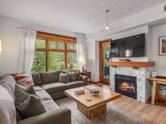 Cozy up by the fireplace in this inviting living room, featuring a plush sectional sofa perfect for relaxing.
