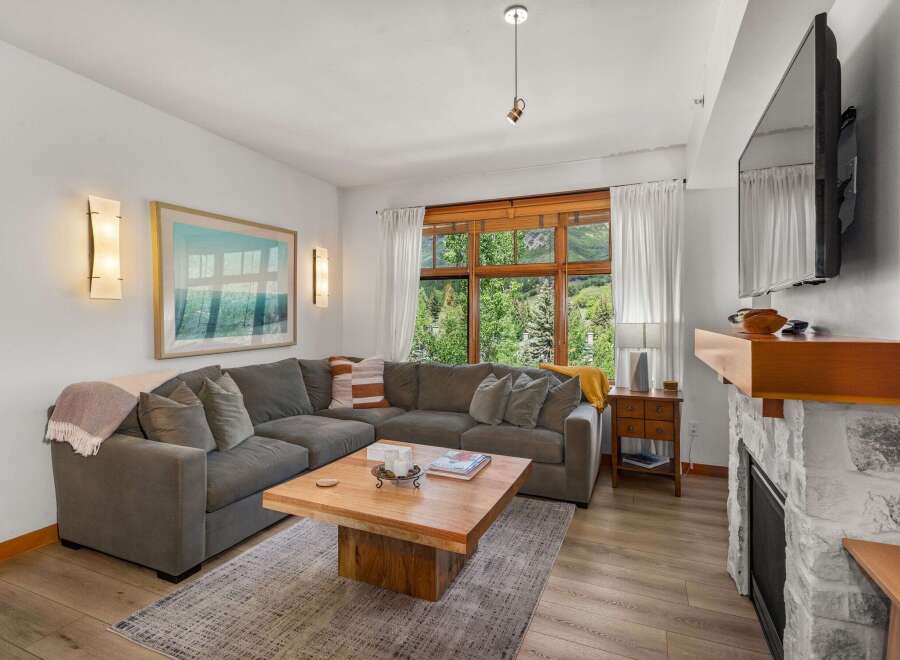 Experience breathtaking mountain views from this stunning living room, featuring a large sectional sofa perfect for cozy evenings.