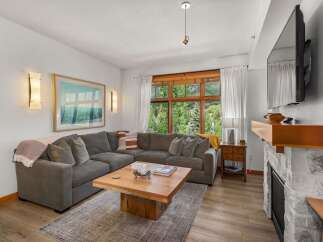 Experience breathtaking mountain views from this stunning living room, featuring a large sectional sofa perfect for cozy evenings.
