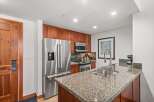 Experience modern living in this beautifully appointed kitchen, featuring sleek stainless steel appliances, granite countertops, and rich cherry wood cabinetry.