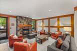Cozy up by the stone fireplace in this inviting living area, featuring comfortable seating and a rustic coffee table.