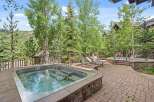 Enjoy a relaxing soak in this luxurious outdoor hot tub, surrounded by lush greenery and mountain views.
