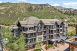 Experience luxury mountain living in this stunning condominium complex, nestled against a dramatic hillside backdrop.