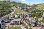 Experience luxury mountain living in this stunning ski resort village, featuring modern architecture nestled amidst lush green slopes and majestic peaks.