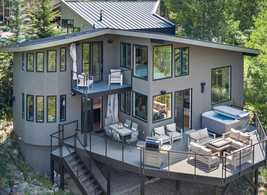Experience luxury outdoor living with this stunning multi-level deck featuring a spacious hot tub and a cozy fire pit area, perfect for entertaining.