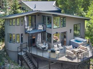 Experience luxury outdoor living with this stunning multi-level deck featuring a spacious hot tub and a cozy fire pit area, perfect for entertaining.